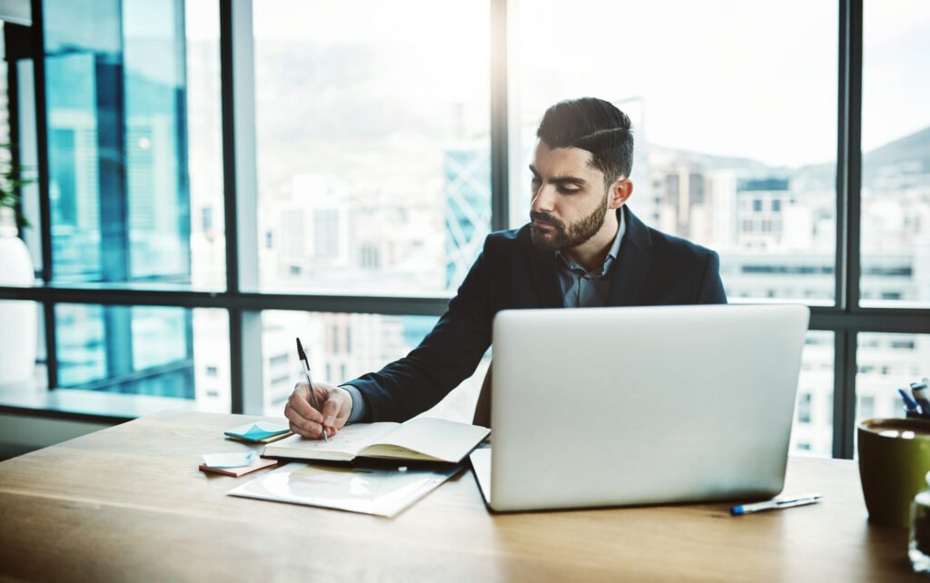 man sat at desk writing