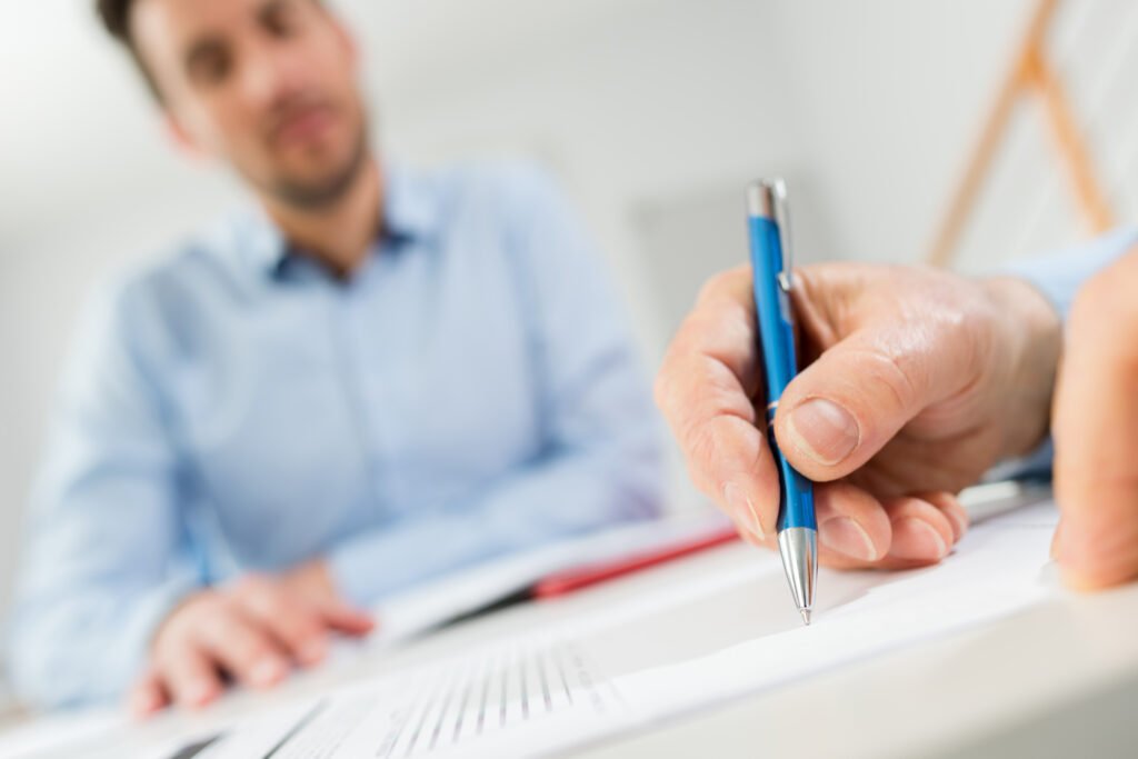man signing documents
