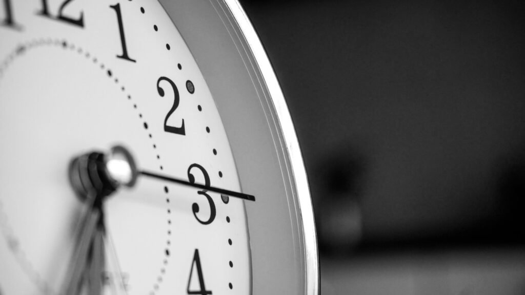 A close up of a ticking analogue clock