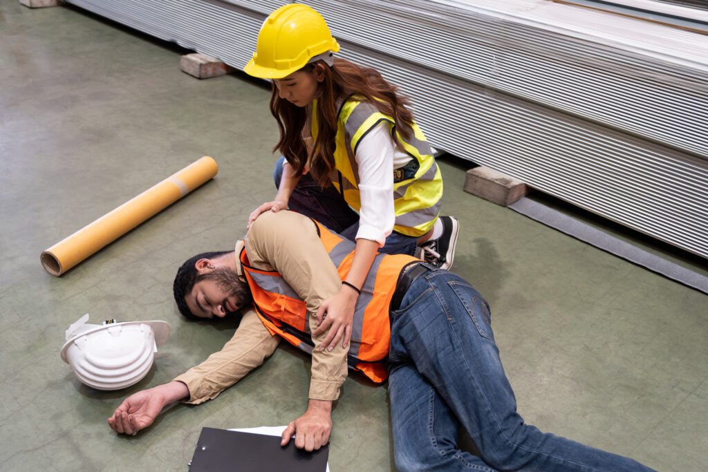 A man being checked on by their colleague after an accident