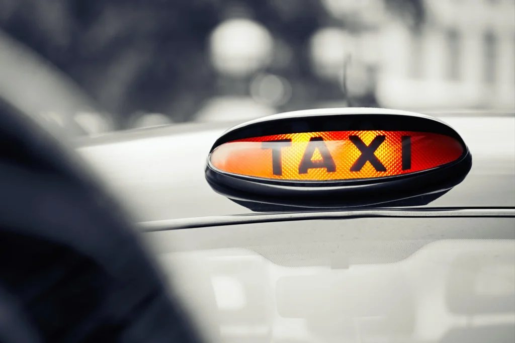 A close-up of a Hackney cab's taxi sign lit up